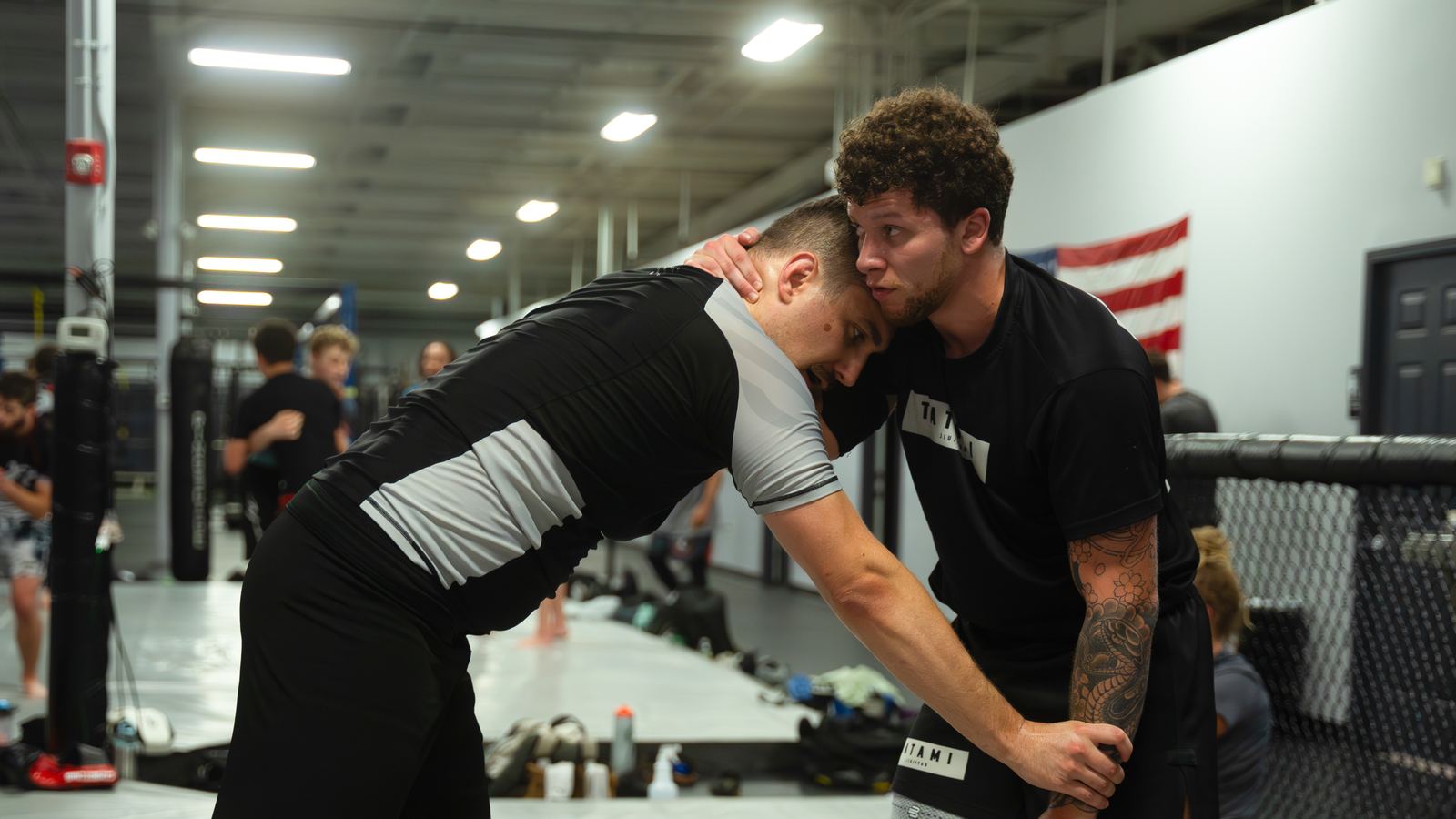 Two students working close range, one controlling the head and neck of the other.