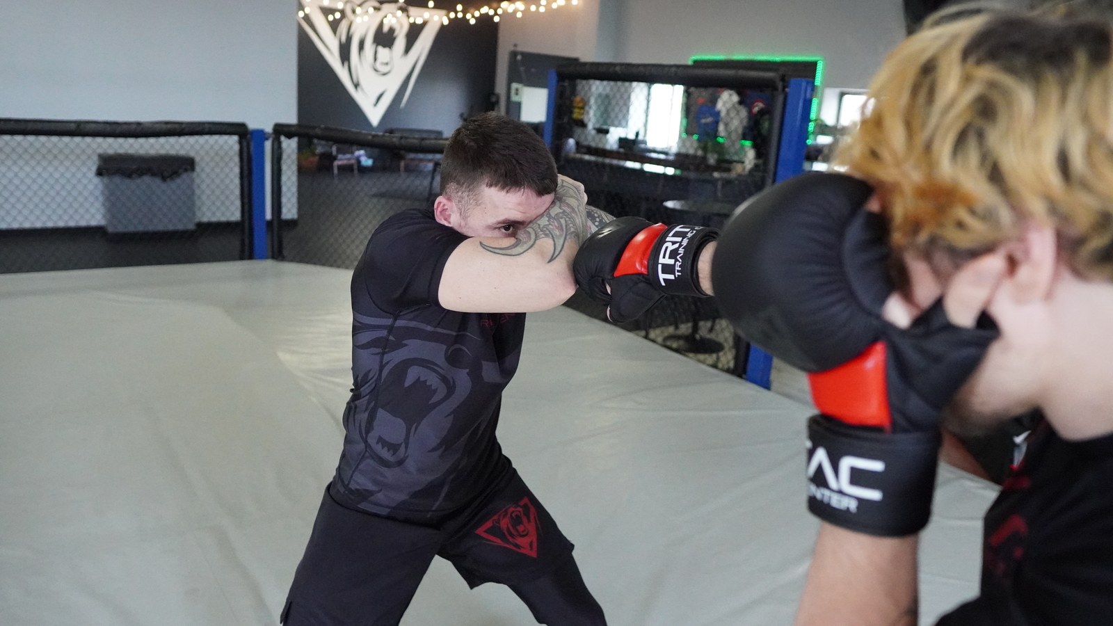 A punch landing on a partner's cover during a coached standing defense drill.